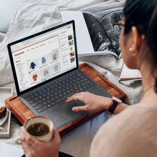 Femme faisant du shopping en ligne sur son MacBook avec un café